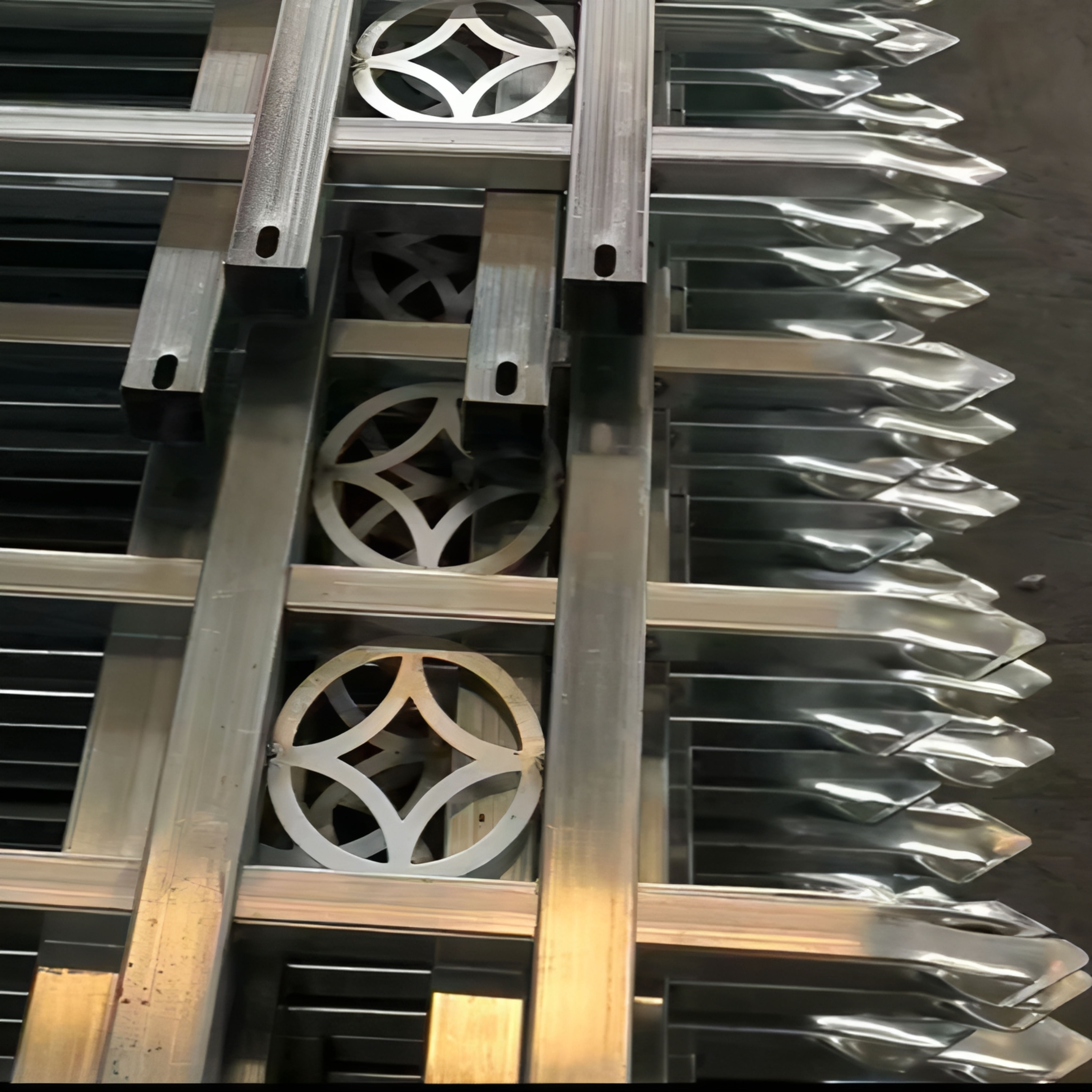 The beautifully patterned fence is being welded